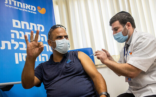 A man in his 30s receives a third COVID-19 vaccine dose, at a vaccination center in Jerusalem, on August 24, 2021. (Yonatan Sindel/Flash90)