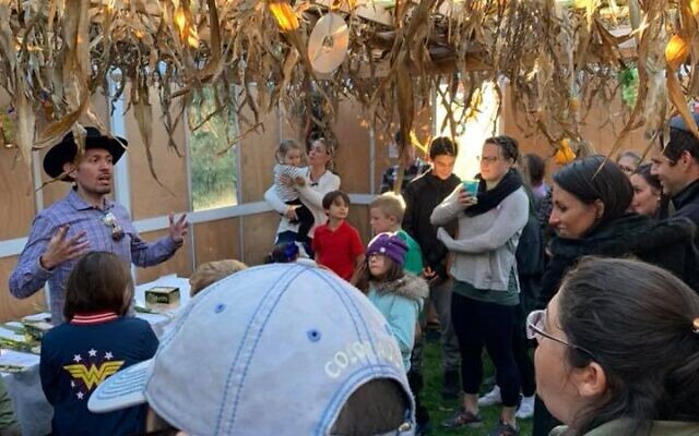 Rabbi Micah Miller leads a family program in the sukkah of Temple of Aaron.