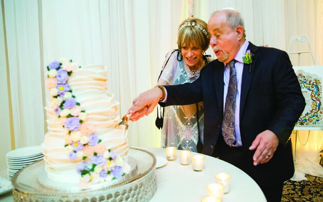 Sheila and Howard cut the multi-tiered wedding cake. (Credit: Life on Film Photography)