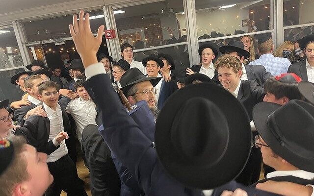 Photos by Allen H. Lipis // As the march approached Yeshiva Ohr Yisrael, a group of students came out to welcome the Torah to its new home.