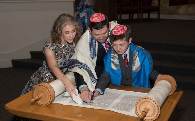 Photo By Glenn Prince Photography // Sam Sernovitz reads from the Torah as his parents, Becky and Rabbi Larry Sernovitz stand by.