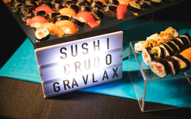 Colorful sushi station with lighted signage.
