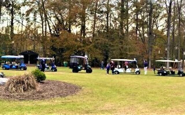 Several golf carts, decorated with Chanukah festive décor, line up to parade during the event.