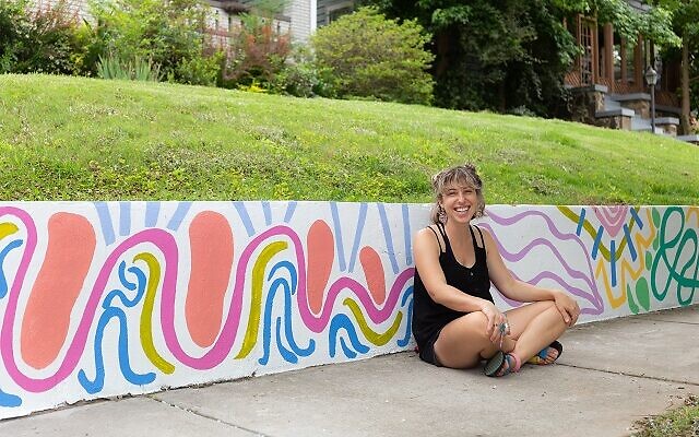 Beigh rests in front of her Westview wall mural.