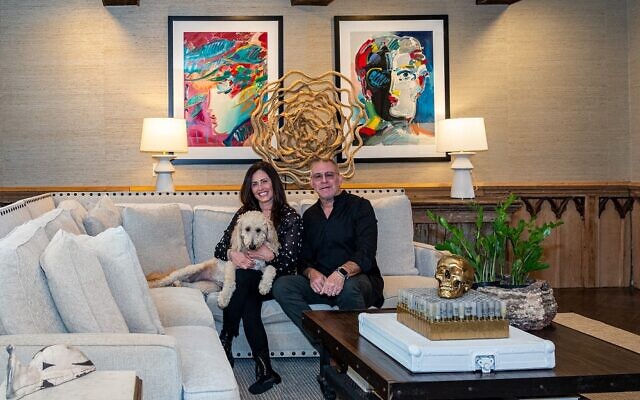 Jody and Cary Goldstein chill with goldendoodle Lacy in front of a colorful Peter Max diptych. // Photography by Howard Mendel