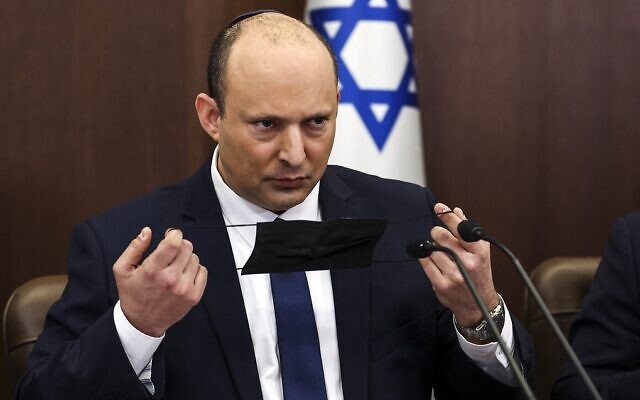 Prime Minister Naftali Bennett handles his mask during a cabinet meeting at the prime minister’s office in Jerusalem, on April 10. // Credit: Ronen Zvulun/Pool Photo via AP