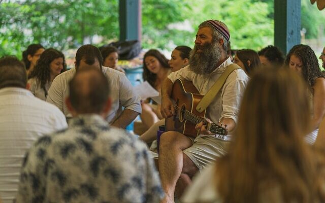 Drew Cohen leads the campers in singing Shabbat prayers and songs // Photo Credit: Jason Belsky