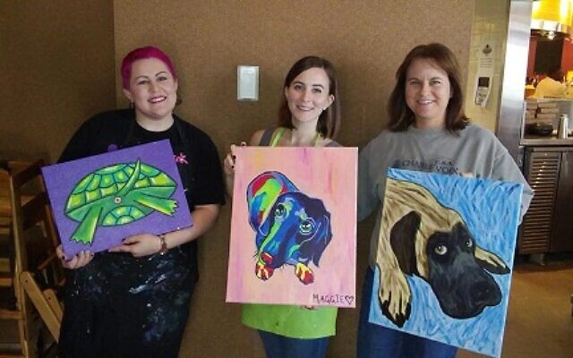 Instructor Aleigha Reott (left) poses with proud students showing off their unique pet creations. Hers is a tortoise.