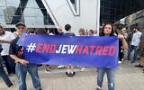 Jeffrey Jacobson and Cheryl Dorchinsky standing outside State Farm Arena before the Roger Waters concert to holding a #ENDJEWHATRED banner.