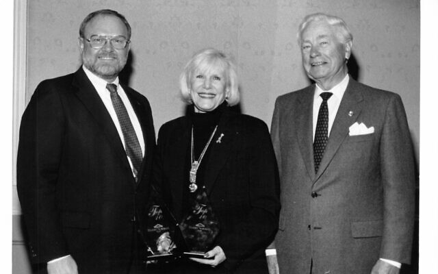 Sandy poses with her broker Rick Brinkman(left) and the late real estate mogul Harry Norman(right).