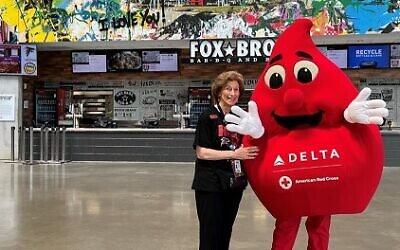 Gail Solomon turned 80 on Nov 6, the same day she commandeered the blood drive at Ahavath Achim to reach her goal of 80 pints. Here, she poses with a drop of blood at Mercedes-Benz Stadium, her other passion.