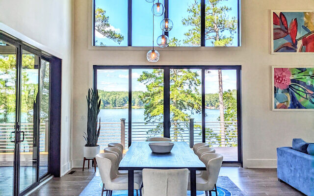 Above: The lake house dining room, with Jonathan Adler rug, has breathtaking views from every angle // Photo by Kate Kolouris