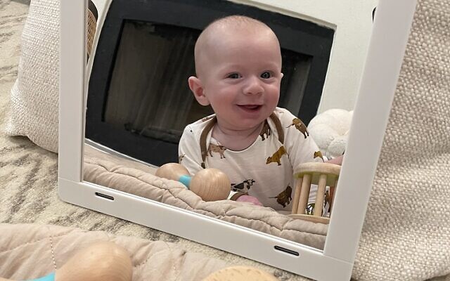 Jett Wolfe doing tummy time with the LOVEVERY mirror and rattles.