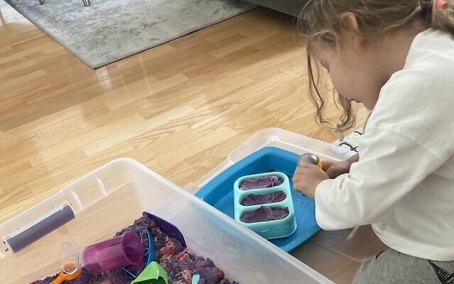 Ella Cohen playing with her DIY sensory bin.