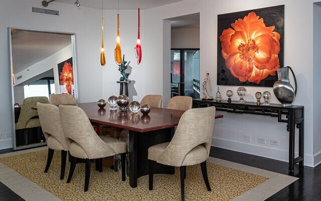The dining table took six men to install in the condo. The spectacular floral art is by Parish Kohanim.