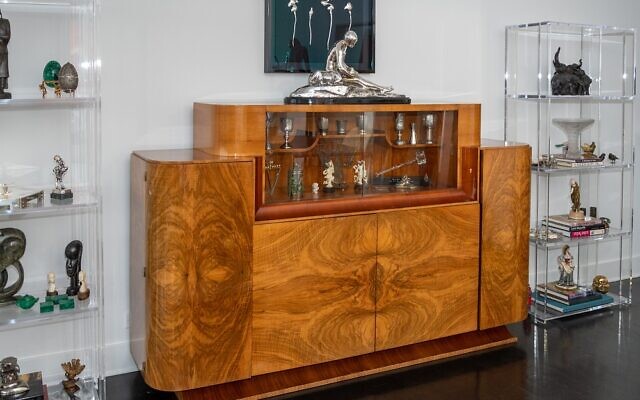 This mid-century modern burl wood unit serves as a focal point with objects d’art on both sides, including the silver squiggles (above) from the Mandarin Oriental Hotel in Manhattan.
