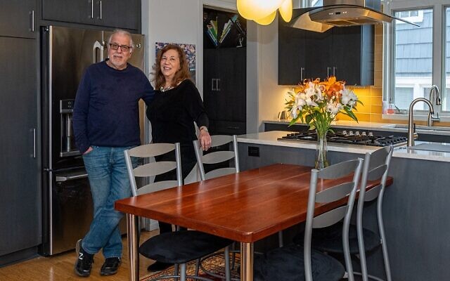 Adele and Larry Pett enjoy their kitchen. The light fixture is from Lucca, Italy. Larry made the kitchen table out of cherry wood. The ochre backsplash echoes the trim around the fireplace // Photos by Howard Mendel