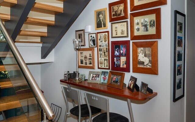 Three levels of glass stairs expose a nook of family photos where Larry made the picture frames.
