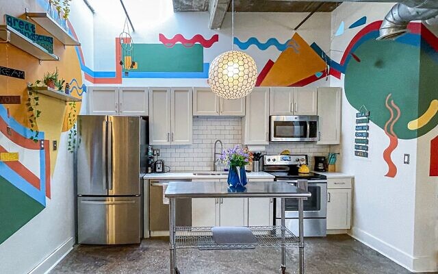 The loft’s kitchen is enveloped in Jamin’s mural wall design