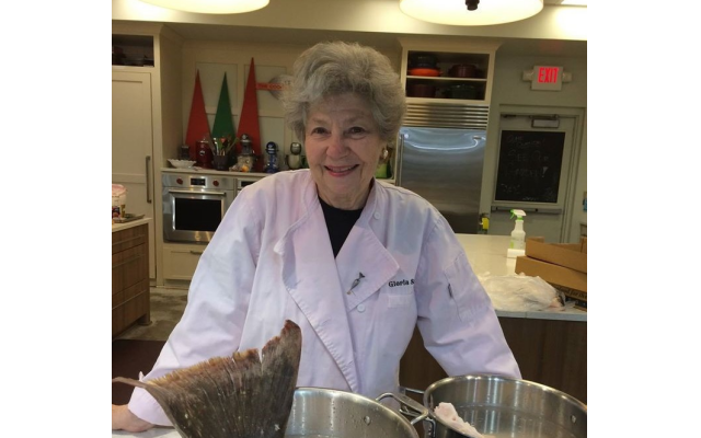 Gloria Smiley, food stylist, prepares a large halibut tail in her huge inventory of pots and equipment.