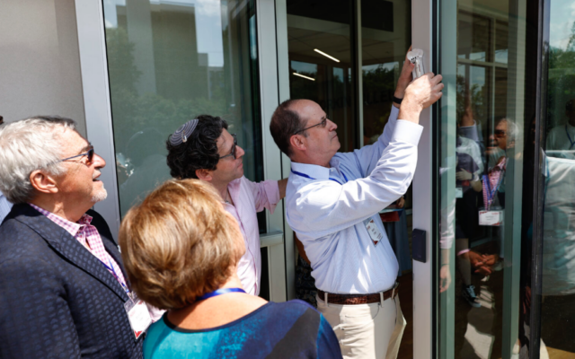 Kenny Orkin affixes a mezuzah to the Hillel Center named in honor of his family // Photo Credit: Andrew Davis Tucker/UGA