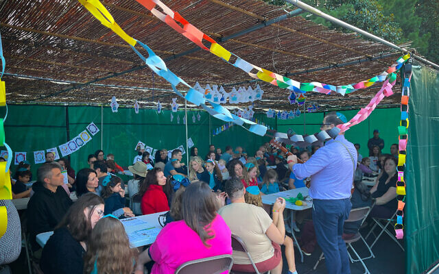 Lower School families joined to sing and spend time together under the sukkah.