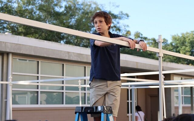 Micah Bank, Epstein Class of 2024, helps build the school sukkah with his class.