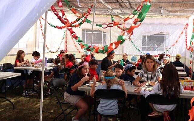 During Sukkot, students gather by grade for lunch in the sukkah at Epstein.