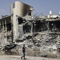 A man walks past Sderot police station, which was destroyed during battles to dislodge Hamas gunmen inside, on Oct. 8 // Photo Credit: RONALDO SCHEMIDT/AFP/Times of Israel