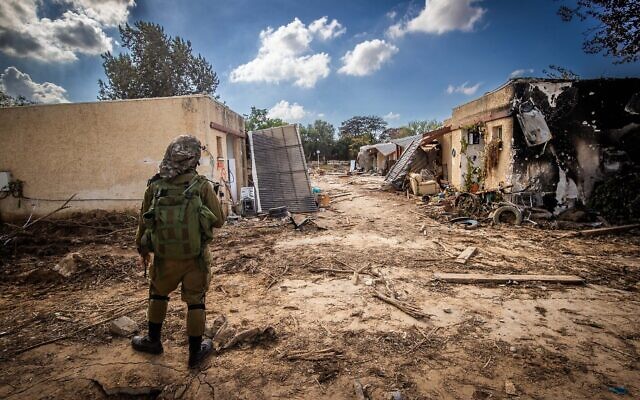 An IDF soldier stands amid destruction caused by Hamas terrorists in Kibbutz Kfar Aza, near the Gaza border, Oct. 15, 2023 // Photo Credit: Chaim Goldberg/Flash90/Times of Israel