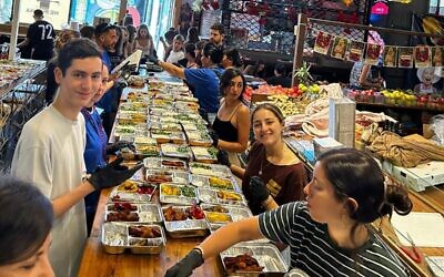 Israeli volunteers, including tens of teenagers, at work at Shuk Tzafon in Tel Aviv making meals for Israeli soldiers and others in need, Oct. 12, 2023 // Photo Credit: Bar Mandel/JTA