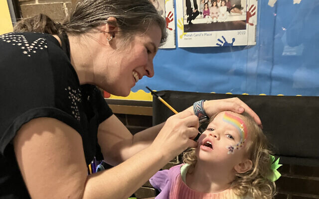 Getting her face painted for the Chanukah bazaar was 2-year-old Lila Sella.
