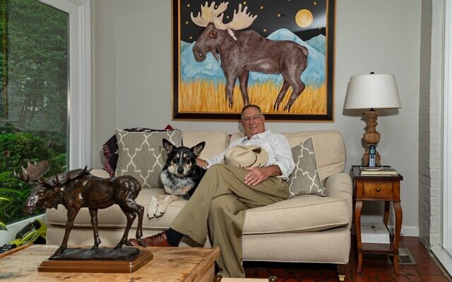 Henry Bauer chills in the sunroom with dog, Scooter, in front of Anne Hathaway’s whimsical watercolor, “Moose Under the Stars and Moon.”  // Photos by Howard Mendel