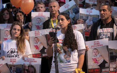 Israelis hold photographs of the Bibas family, and orange balloons, at a press conference calling for the release of 10-month-old Kfir, 4-year-old Ariel, and their parents Shiri and Yarden Bibas at "Hostage Square" in Tel Aviv, Nov. 28, 2023 // Photo Credit: Miriam Alster/Flash90/JTA