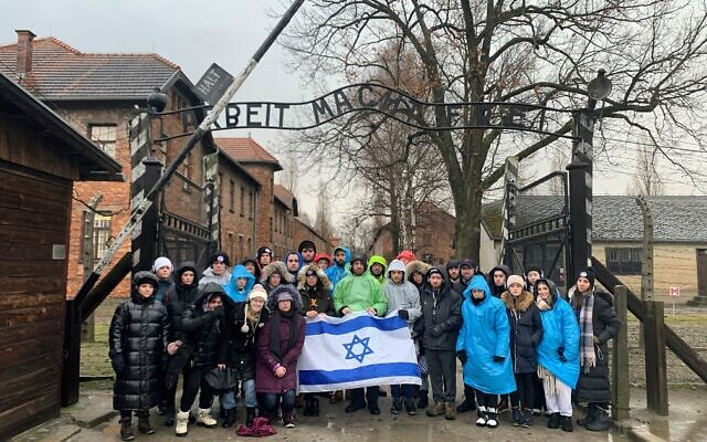 The Meor students stand at the entrance to Auschwitz.