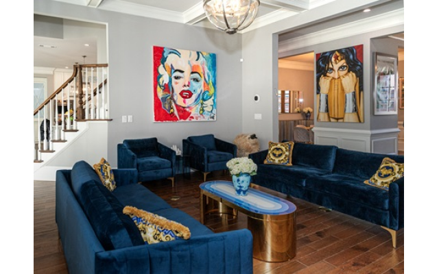The Holland living room in blue velvet has a painting of Marilyn Monroe from a Tel Aviv gallery, adjacent to Rohlf’s painting of Wonder Woman reading “The Confident Woman” // All Photos by Howard Mendel