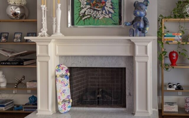 The fireplace has a vintage Hermes graffiti scarf and a collectable Be@rbrick from Japan, below a limited-edition Louis Vuitton skateboard.