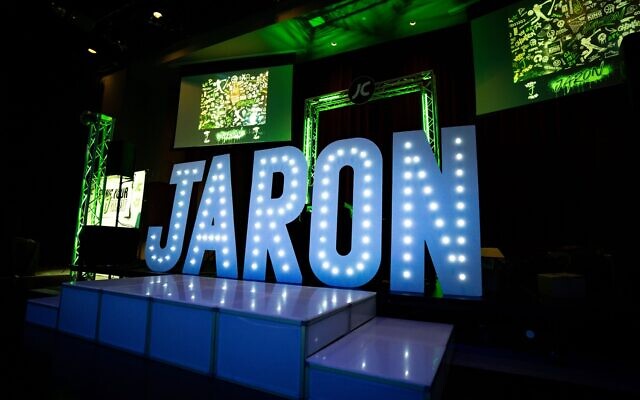 The dramatic JARON neon sign lights up the room.