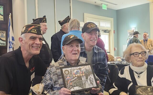 Hibby Margol (center), with his wife, Betty Ann of 75 years, and representatives from local veterans’ groups, showing one of the special honors presented to him for his military service // Photo Credit:  Helen Scherrer-Diamond