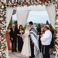The elaborate chuppah was in red, peach, and white tones.