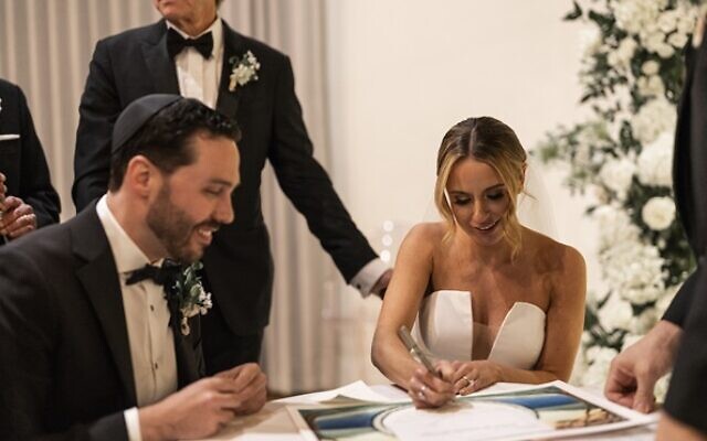 The couple signed the ketubah with family looking on.