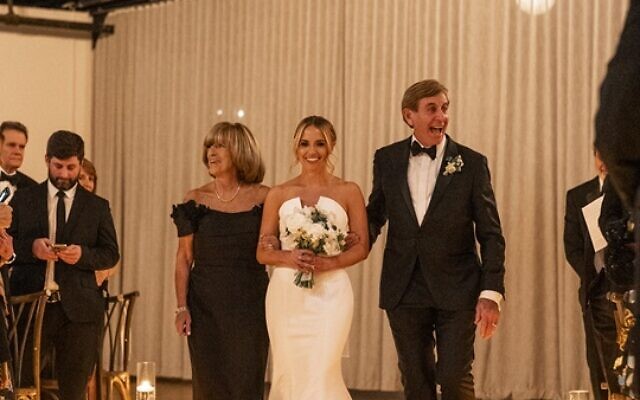 Gleeful father, Larry Wolkin, and mom, Susan, walked Paige down the aisle.