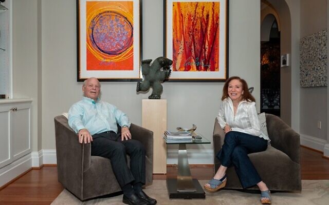 Rick and Lorri relax in front of two tangerine hued Chihuly lithographs. (Left) Indian Basket, Ikebana Series (Right). In the center is an Inuit carving “Dancing Bear”// Photos by Howard Mendel