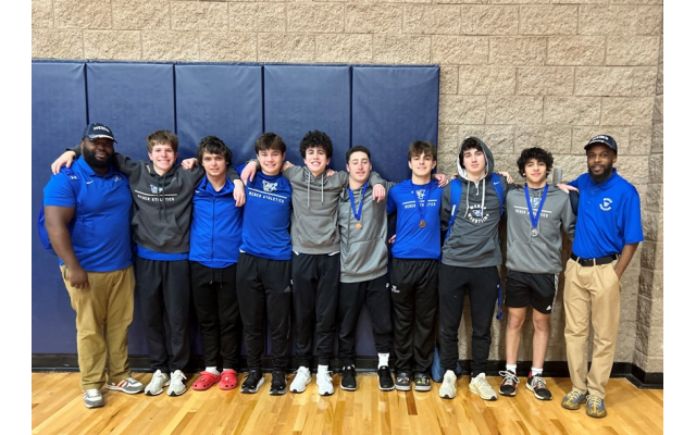 The 2023-24 Weber School wrestling team, supported by community coaches Tim Bozeman and Chris Hilton, is looking forward to further success next winter // Photo Credit: Rebecca McCullough