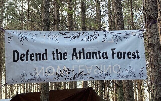 A banner strung between the trees near the planned site of Atlanta’s police training facility. AJT freelance writer Dave Schechter won a 2024 Award of Excellence from the Atlanta Press Club for his article from March 2023, “The Jews of Stop Cop City” // File photo