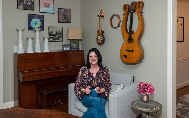 Miller poses in front of handmade guitars that her Savannah grandfather, a luthier, crafted.