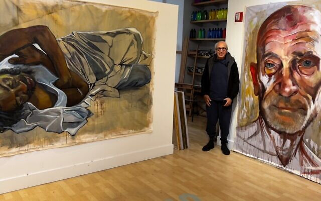 Clive Bank poses in front of two of Gershman’s huge paintings.