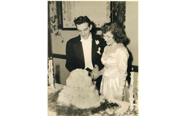 Newlyweds Shirley and Sully slice their wedding cake.