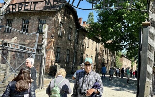 Alan Kaplan stands outside the gates to the Auschwitz-Birkenau concentration camp.