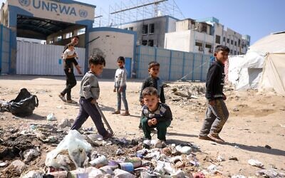 Children play around waste in front of the closed UN agency for Palestinian refugees UNRWA headquarters in Gaza City, on May 20, 2025 // Photo Credit: Bashar TALEB/AFP/Times of Israel